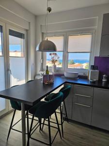 メドゥリンにあるEvitaのキッチン(黒いテーブル、椅子付)、窓