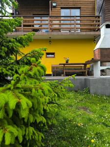 a yellow building with a bench in front of it at House Blanka,kuća za odmor in Skrad