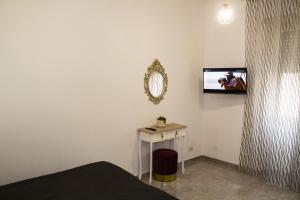 a bedroom with a tv on the wall and a table at La Terrazza di Stefy in Acilia