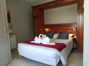 1 dormitorio con 1 cama y 2 toallas blancas en Hotel de la Terrasse en Berck-sur-Mer