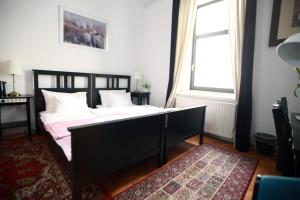 1 dormitorio con 2 camas, ventana y alfombra en BIT apartments, en Liubliana