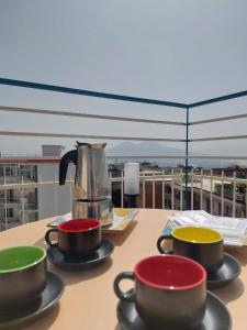un tavolo con tre tazze e un bollitore per il tè sopra di yoyo house Napoli a Napoli