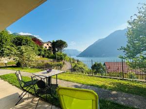 a table and chairs on a patio with a view of the water at Incanto Nesso Parking and Lake View in Nesso
