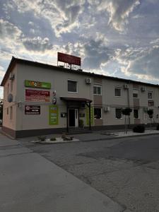 a large building with a sign on top of it at Alice Vendégház in Kalocsa