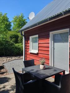 a table with chairs in front of a red house at Ferienhaus Svensson Altheide in Altheide