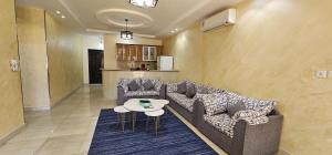 a living room with two couches and a table at شذا المصيف لبيوت العطلات in Al Shafa