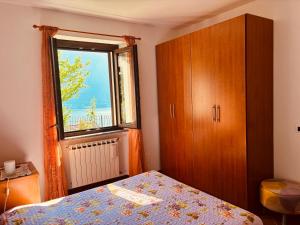 a bedroom with a bed and a window at Incanto Nesso Parking and Lake View in Nesso