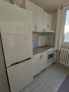 a kitchen with a white refrigerator and a stove at Aura apartman Sarajevo in Sarajevo
