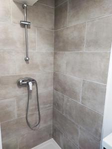 La salle de bains est pourvue d'une douche avec un pommeau de douche. dans l'établissement G-Logement-Francilien Goussainville CDG, à Goussainville