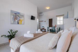 a bedroom with two beds and a dining room at Studios Eliza in Livadi