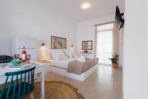 a bedroom with a bed and a desk and a table at Studios Eliza in Livadi