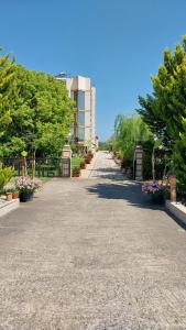 droga z kwiatami i drzewami i budynek w obiekcie Different Hotel & Restaurant w mieście Divjaka
