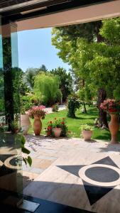 Blick auf einen Garten mit Blumenvasen in der Unterkunft Different Hotel & Restaurant in Divjaka