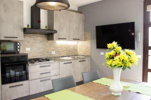 a kitchen with a table with a vase of flowers on it at Appartamento in Stile Minimale in Pontedera