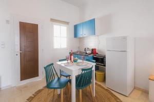 a kitchen with a table and chairs and a refrigerator at Studios Eliza in Livadi