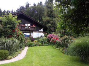 een tuin voor een huis met bloemen bij Blumenpension Strauss - Ferienwohnungen in Ossiach