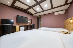 Habitación de hotel con 2 camas y TV de pantalla plana. en Hotel Trip en Incheon
