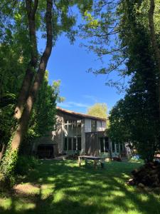 una casa con un banco en el patio en Séjour au bord de l'eau, en Saint-Maixent-lʼÉcole