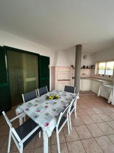 uma mesa de jantar com cadeiras e uma cozinha em Fusella Country House/Villa a Polignano Vista Mare em Polignano a Mare