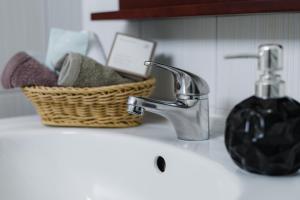 a bathroom sink with a faucet and a basket of towels at Studios Eliza in Livadi