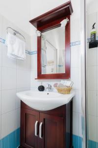 a bathroom with a white sink and a mirror at Studios Eliza in Livadi