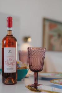 a bottle of wine and a glass on a table at Studios Eliza in Livadi