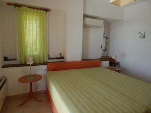 プラキアスにあるNefelesのベッドルーム1室(ベッド1台、テーブル、窓付)
