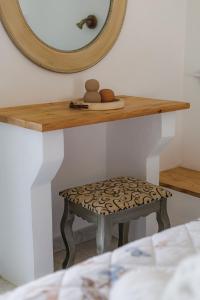 a mirror and a stool on a shelf with a stool at Studios Eliza in Livadi