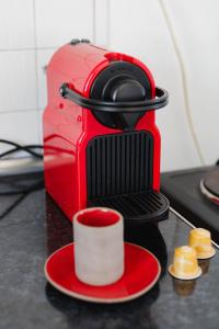 a red camera with a red plate and a cup at Studios Eliza in Livadi