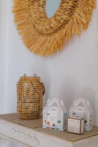 a shelf with three milk containers and a wicker basket at Studios Eliza in Livadi