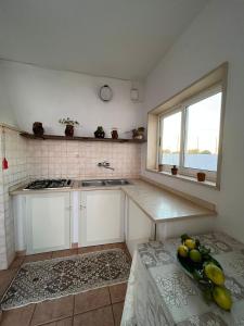 a kitchen with a bowl of fruit on a table at Fusella Country House/Villa a Polignano Vista Mare in Polignano a Mare