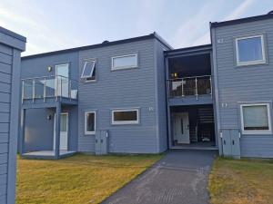una casa gris con una entrada delante de ella en Nydelig selveier leilighet med gratis parkering på stedet, en Alta