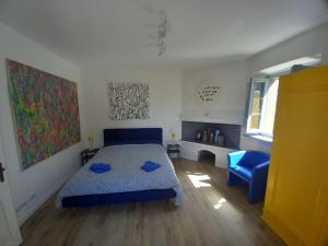 a bedroom with a blue bed and a blue chair at Chianti Art Room in Poggibonsi