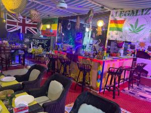 a room with chairs and a bar with a rainbow at peace garden hostel & camp in Luxor