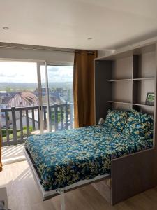 een slaapkamer met een bed en een balkon bij beau studio au bord de la mer in Blonville-sur-Mer