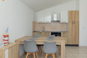 a kitchen with a wooden table and four chairs at Perinic, No 2 in Vrsi +12 photos