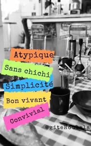 un tavolo con diversi cartelli in una cucina di HOULALA Gîte & Chambres d'hôtes a Pont-Évêque