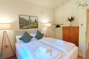 a bedroom with a large white bed with blue pillows at Homely Stay Velosoph Quartier in Bayrischzell