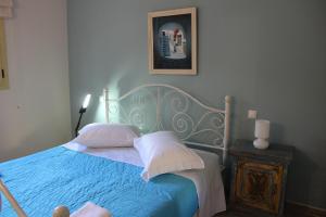 a bedroom with a blue bed and a picture on the wall at Yellow House close to the beach in Alikanas