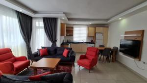 Il comprend un salon avec un canapé et des chaises ainsi qu'une cuisine. dans l'établissement AQUA CİTY SUİT, à Antalya