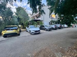 una fila de autos estacionados al lado de una calle en Rooms & Apartments Hegic, en Zadar