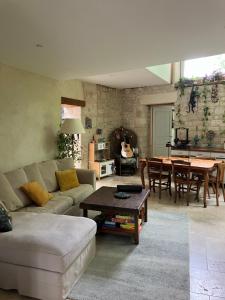 una sala de estar con un sofá y una mesa en Séjour au bord de l'eau, en Saint-Maixent-lʼÉcole