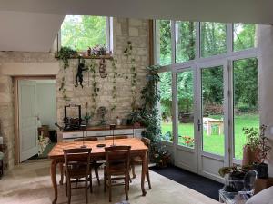 Un comedor con mesa y sillas de madera. en Séjour au bord de l'eau, en Saint-Maixent-lʼÉcole 18 fotos más