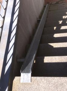 uma escada com um corrimão de metal preto ao lado de um edifício em Dallacker 8, FeWo 3 em Duhnen