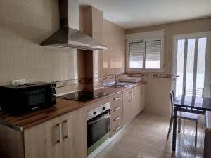 una cocina con fregadero y estufa en La Encantada, en Huéscar