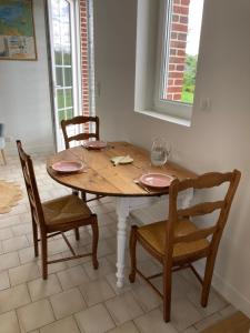 een eettafel met 2 stoelen en een tafel en een raam bij Clos Phitarra, charmant gîte pour 2 personnes à 7 mns d'Etretat in Les Loges