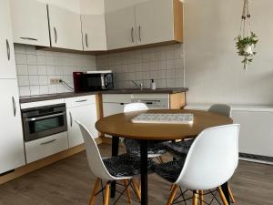 a kitchen with a wooden table and white chairs at Jardin Botanique in Brussels
