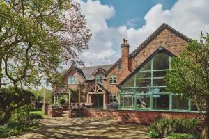 an exterior view of a brick house with large windows at Sandy Hill Farm in Curborough