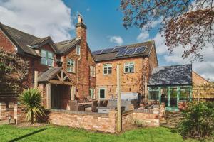 a brick house with solar panels on the roof at Sandy Hill Farm in Curborough