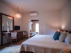 a bedroom with a bed and a desk and a mirror at Dracos Hotel in Parga
